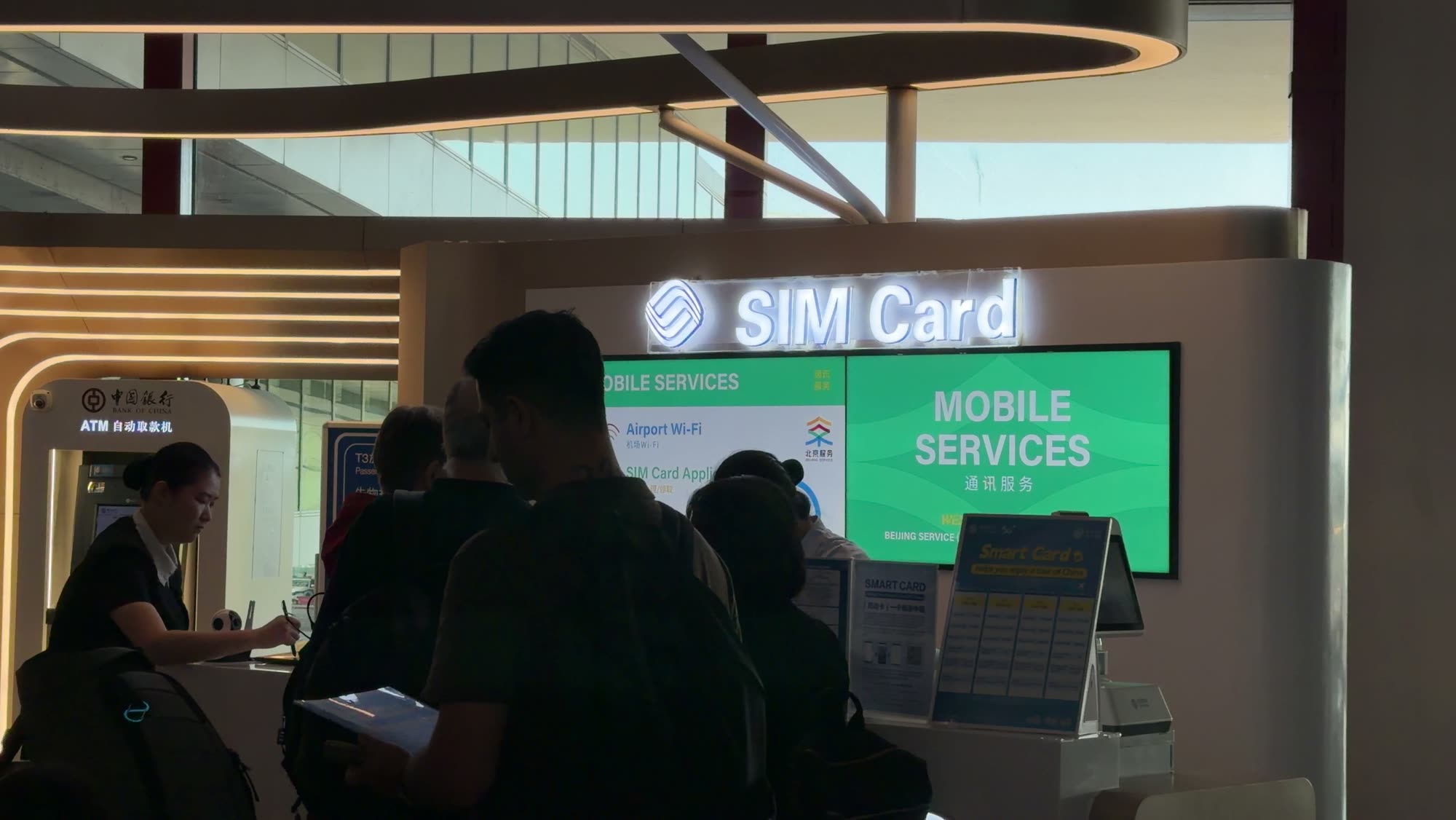 The China Mobile SIM Card counter in the arrivals hall at Beijing Capital Airport Terminal 3, with travellers waiting